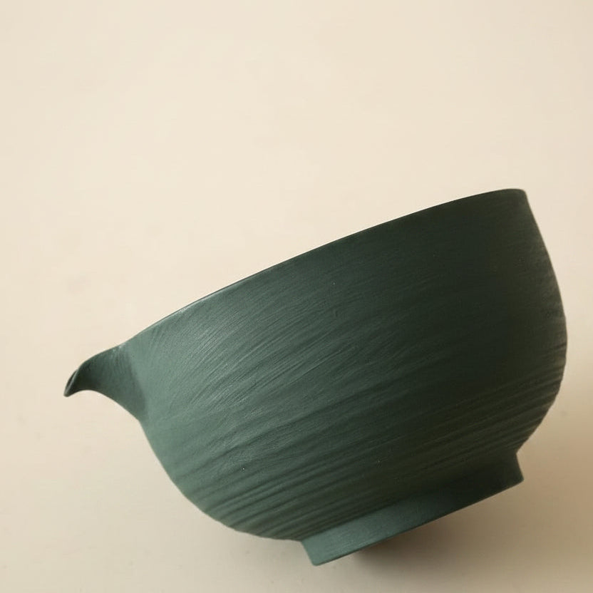 The green chawan tilted to show the ribbed outer wall.