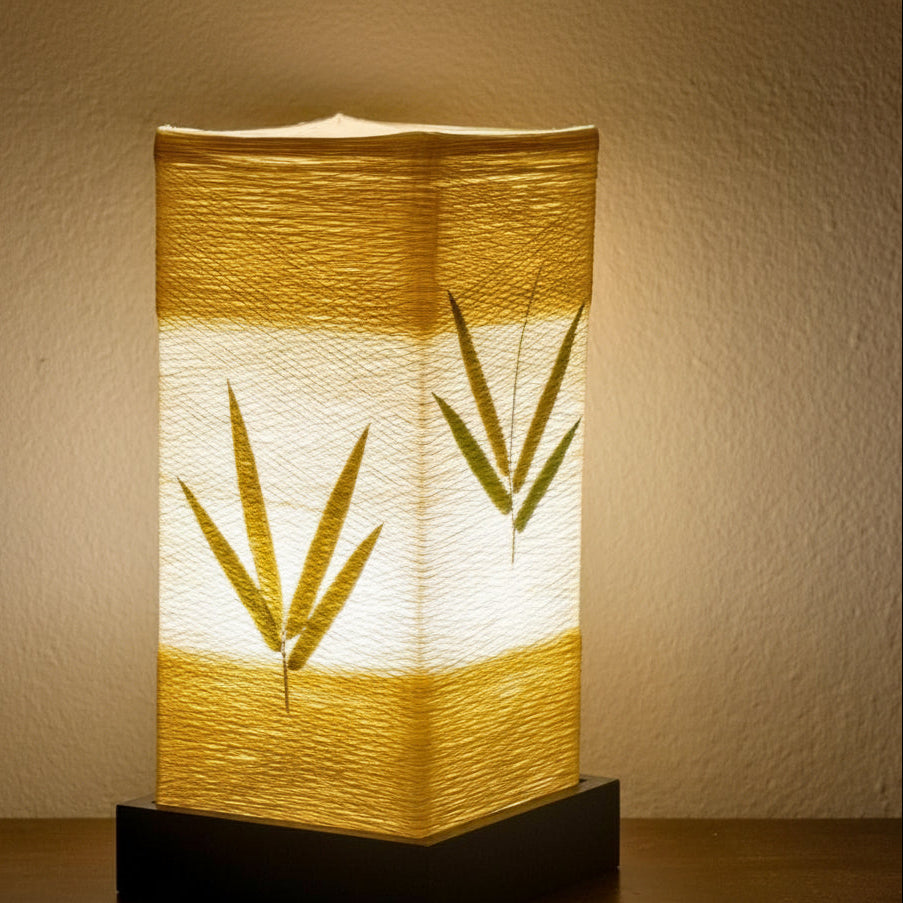The lantern lit from within, the leaves dark against the glowing paper