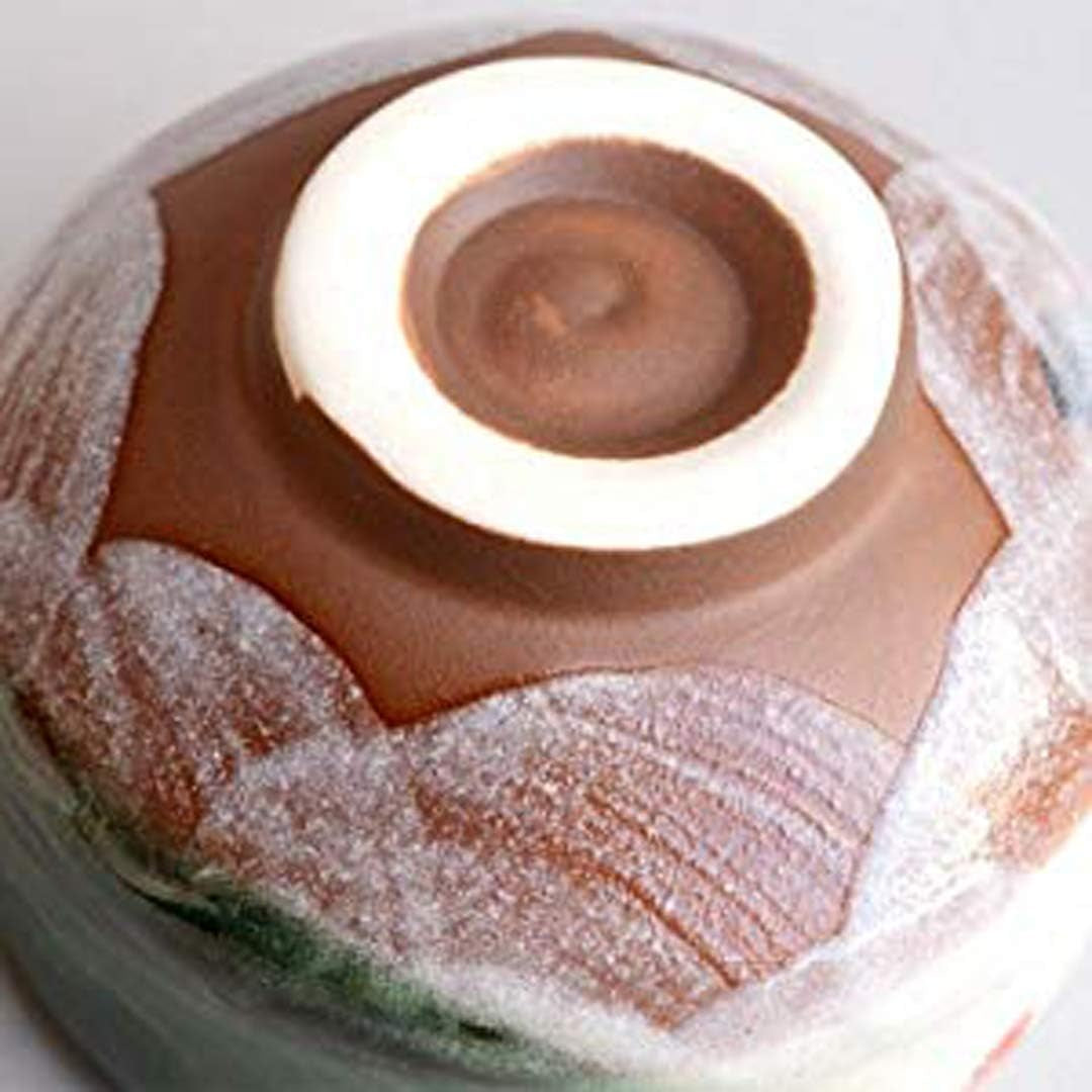 The underside of the bowl, the white foot ring against bare brown clay